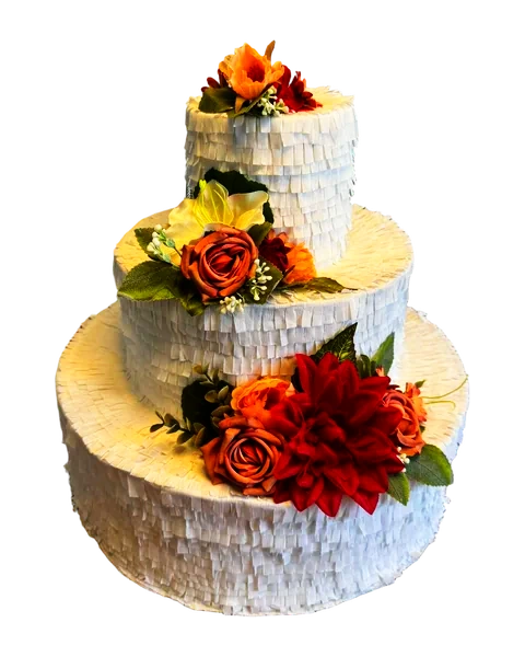 Piñata en forma de tarta de tres pisos de flecos blancos, decorada con flores en tonos naranja y granate, recortada sobre fondo liso.
